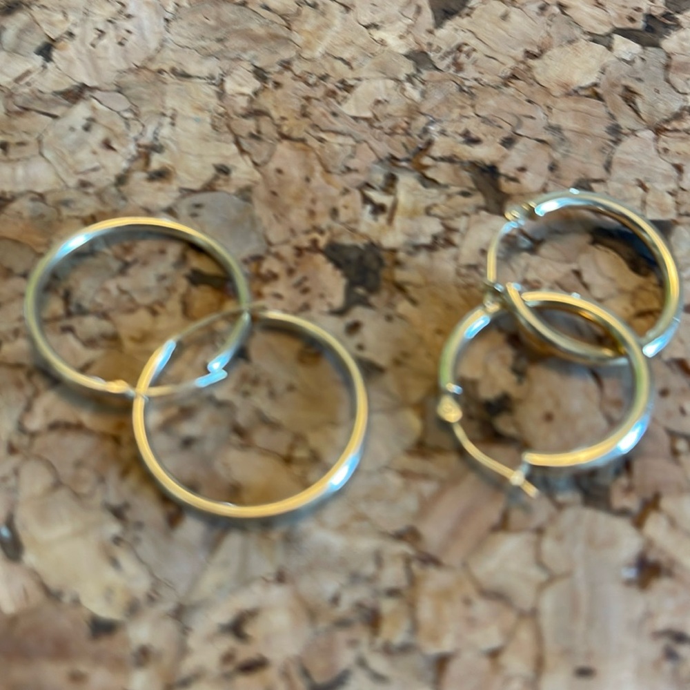 Two pairs of 14 K gold hoop earrings .